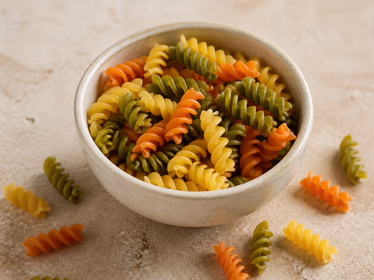 H&eacute;lices de pasta vegetales tricolor en un cuenco